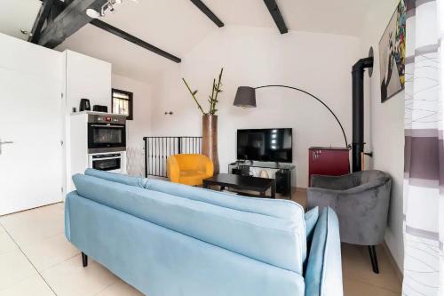 a living room with a blue couch and chairs at Veyrier du lac petite maison proche d'Annecy in Veyrier-du-Lac