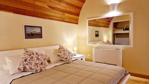1 dormitorio con 1 cama grande y espejo en Maison Des Fleurs, en Nápoles