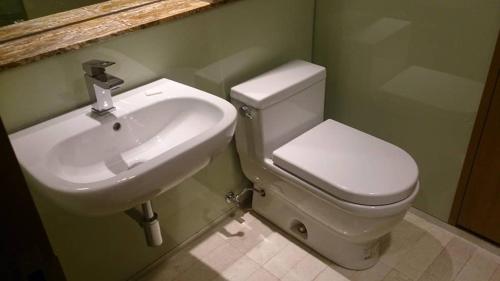 a bathroom with a white toilet and a sink at SOHO SUITES KLCC by RED HOMES in Kuala Lumpur