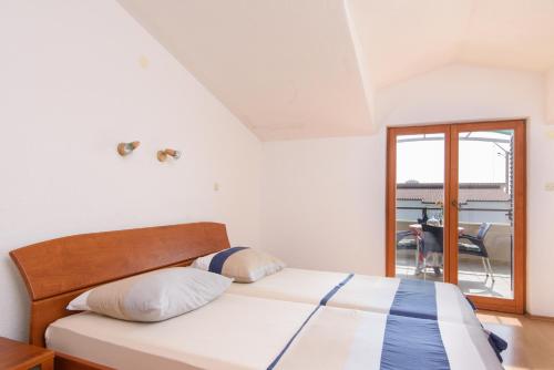 a bedroom with a bed and a balcony at Villa Marcelina in Seget Vranjica