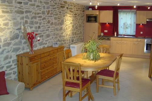 uma cozinha e sala de jantar com uma mesa de madeira e cadeiras em Holiday home Gîte rural Côté Fagnes em Jalhay