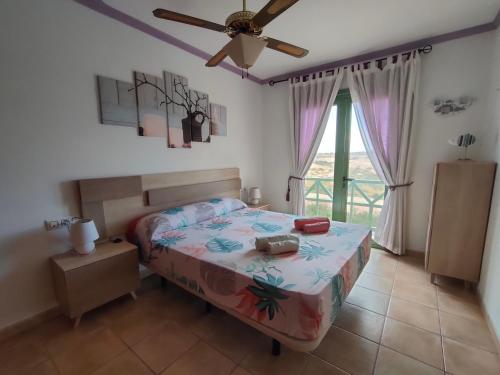 a bedroom with a bed and a ceiling fan at Estupendo Apartamento Gaudia in Caleta De Fuste