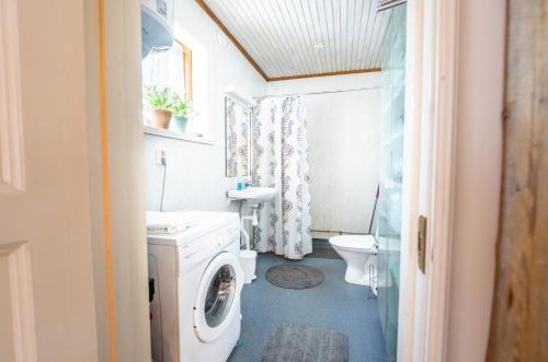 uma casa de banho com uma máquina de lavar roupa e um WC em Luleå Village Cabin em Luleå