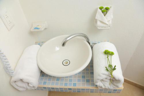 La salle de bains est pourvue d'un lavabo et de serviettes sur un comptoir. dans l'établissement Lorencillo Miramar, à Tampico
