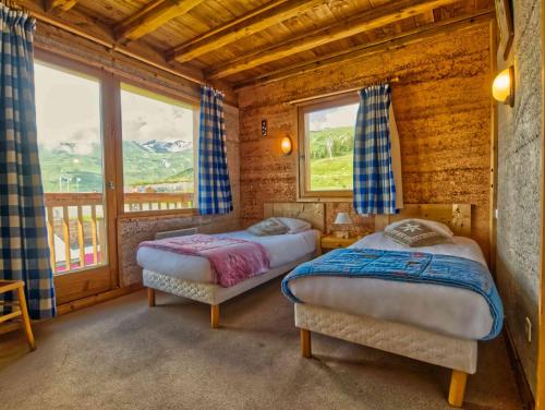 deux lits dans une chambre avec deux fenêtres dans l'établissement Shatzy, à La Rosière