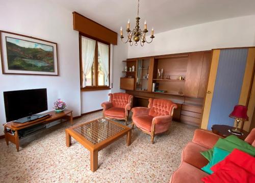a living room with a couch chairs and a television at Villino Carla in Lipomo