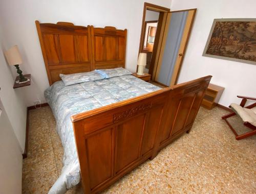 a bedroom with a large wooden bed and a mirror at Villino Carla in Lipomo