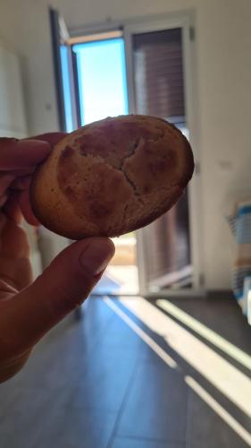 a person holding a chocolate chip cookie in their hand at Casa Trekking Salento Marittima Di Diso in Marittima