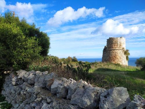 a stone wall and a castle on a hill at Casa Trekking Salento Marittima Di Diso in Marittima
