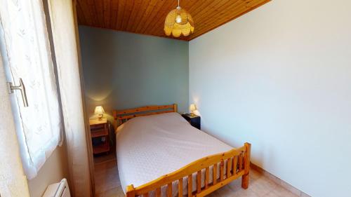 - une petite chambre avec un lit en bois dans l'établissement Villa l'Atlantique, à Saint-Hilaire-de-Riez