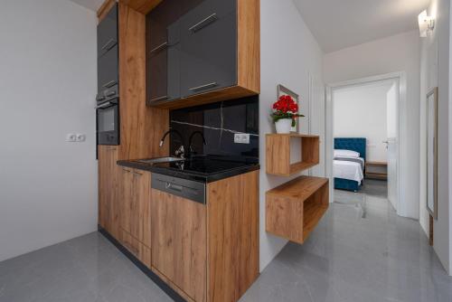 a kitchen with wooden cabinets and a sink at Appartements VIR in Vir