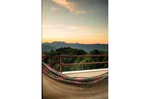 a hammock on a balcony with a view of the mountains at Condomínio Familiar - Aptos Novos e Completos in Nova Petrópolis