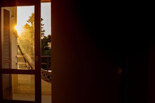 a window view of the sunset from a balcony at Condomínio Familiar - Aptos Novos e Completos in Nova Petrópolis