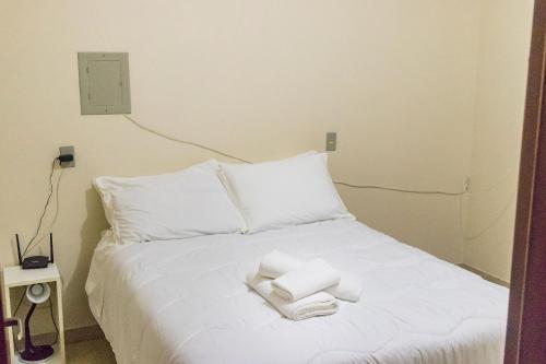 a white bed with towels on top of it at Condomínio Familiar - Aptos Novos e Completos in Nova Petrópolis