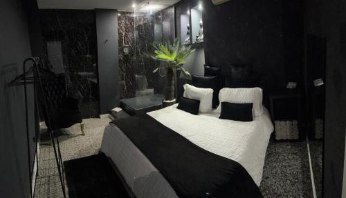 a bedroom with a large bed with white sheets and black pillows at Modern & Central 3 minutes from the River in Vila Nova de Gaia