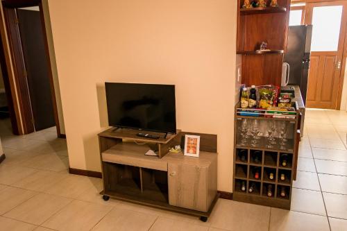 a flat screen tv on a stand in a room at Condomínio Familiar - Aptos Novos e Completos in Nova Petrópolis