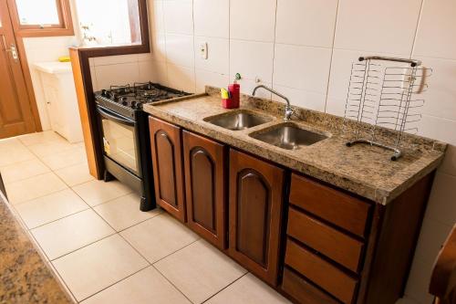 a kitchen with a sink and a stove at Condomínio Familiar - Aptos Novos e Completos in Nova Petrópolis