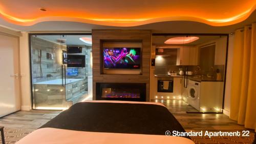 a bedroom with a tv on a wall in a room at Serenity Apartments Bradford in Bradford