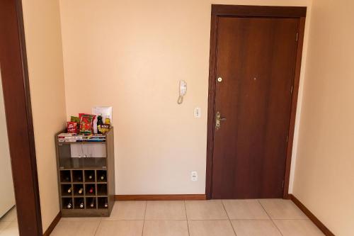 a room with a door and a shelf of wine bottles at Condomínio Familiar - Aptos Novos e Completos in Nova Petrópolis