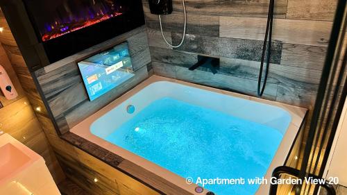 eine Whirlpool-Badewanne mit Fernseher im Badezimmer in der Unterkunft Serenity Apartments Bradford in Bradford