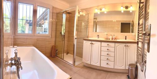 une salle de bain avec une baignoire, un lavabo et une douche dans l'établissement Gulf Stream Villa, aux Issambres