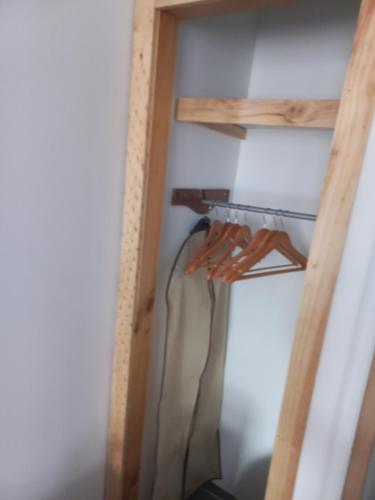 a room with a closet with a wooden shelf at Mini Casa Rocura Valdivia in Valdivia