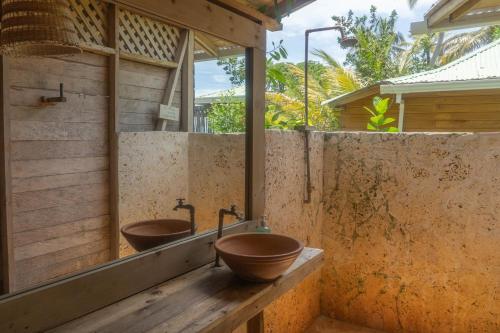 Baño con 2 lavabos y espejo en CasaCoral Hotel, en Puerto Limón