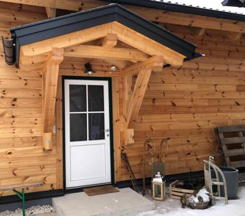 a wooden cabin with a white door on it at MyHolzhaus - zum Wohlfühlen in Gröbming