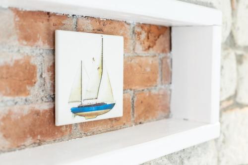 a picture of a boat in a picture frame on a brick wall at Deniz Kabugu Hotel in Alacati