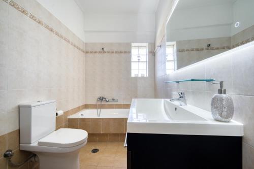 a bathroom with a toilet and a sink and a tub at Sea & Mountain Apartment in Lávrion