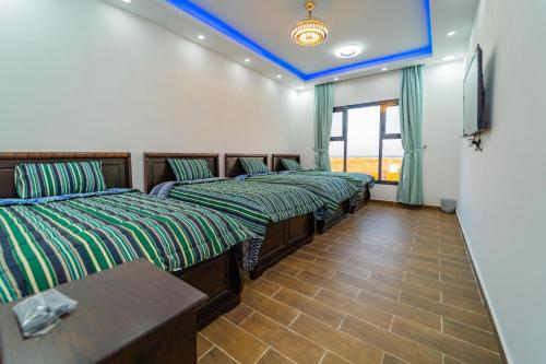a row of beds in a room with a blue ceiling at COMFORT CHALET & APARTMENTS in Al Ḩadd