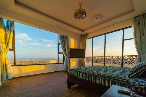 a bedroom with a bed with a view of the ocean at COMFORT CHALET & APARTMENTS in Al Ḩadd