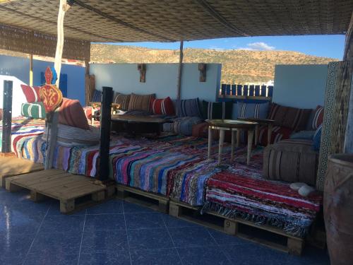 Habitación con cama, mesa y sillas. en Bayti surf hostel, en Agadir