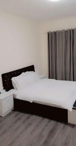 a bedroom with a large bed with a black headboard at Lemas 1001 in Ajman 
