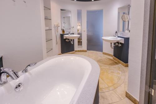 a bathroom with two sinks and a bath tub at Romantik Hotel Gasthaus Rottner in Nürnberg