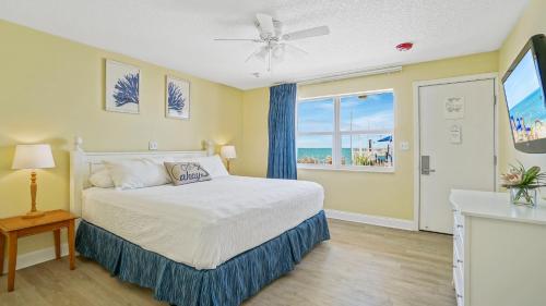 een slaapkamer met een bed en een raam bij Glunz Ocean Beach Hotel and Resort in Marathon