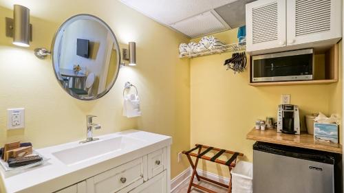 a bathroom with a sink and a mirror at Glunz Ocean Beach Hotel and Resort in Marathon