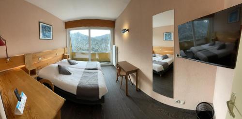 a hotel room with two beds and a window at Logis De La Grande Cascade in Le Tholy