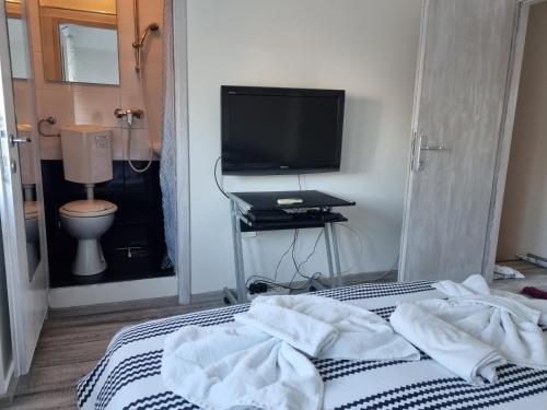 Schlafzimmer mit einem TV und einem Bett mit Handtüchern in der Unterkunft Guest House Roki & Diva in Zadar