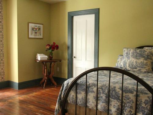 a bedroom with a bed and a table and a door at The Wedding Cake House in Providence