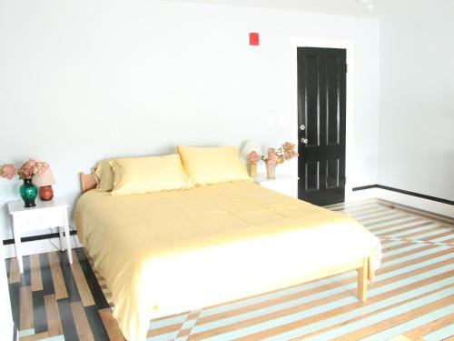 a white bedroom with a bed and a black door at The Wedding Cake House in Providence