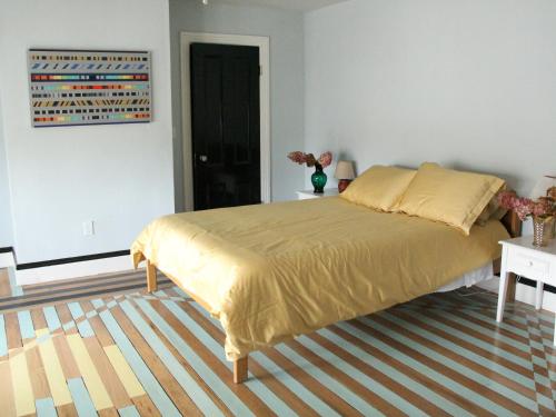 a bedroom with a large bed with a yellow bedspread at The Wedding Cake House in Providence