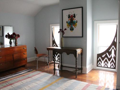a living room with a piano and a dresser at The Wedding Cake House in Providence