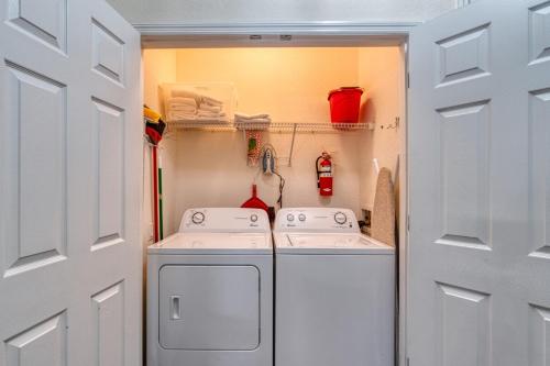 una pequeña cocina con lavadora y secadora. en Deluxe 3 Bedroom Apartment 404 en Orlando