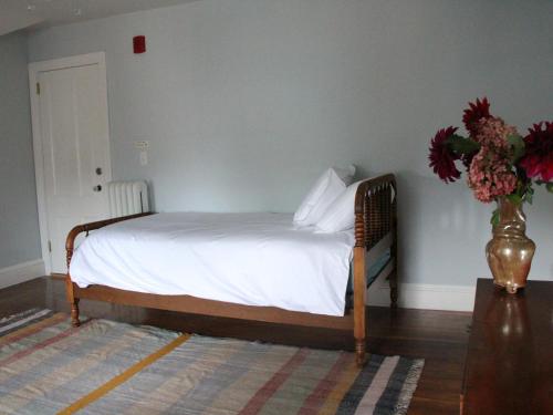 a bedroom with a bed with a vase of flowers at The Wedding Cake House in Providence