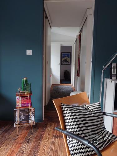 a living room with a chair and a blue wall at Un chalet au Ventoux - Mont Serein in Mont Serein