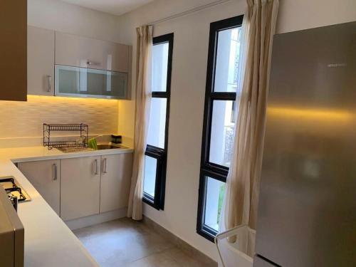 - une cuisine avec des placards blancs et des fenêtres dans une pièce dans l'établissement Tranquilo ,Acogedor y Comodo, à Casablanca