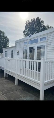 a white mobile home with a white fence at 3 bedroom luxury caravan haven, marton mere in Blackpool
