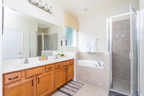 a bathroom with a tub and a sink and a shower at Gorgeous 4Bd Close to Disney w/ Pool @ 4072 Solterra Resort in Davenport