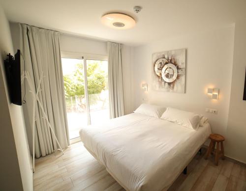 a white bed in a bedroom with a window at Terrace Costa Hotel in Fuengirola